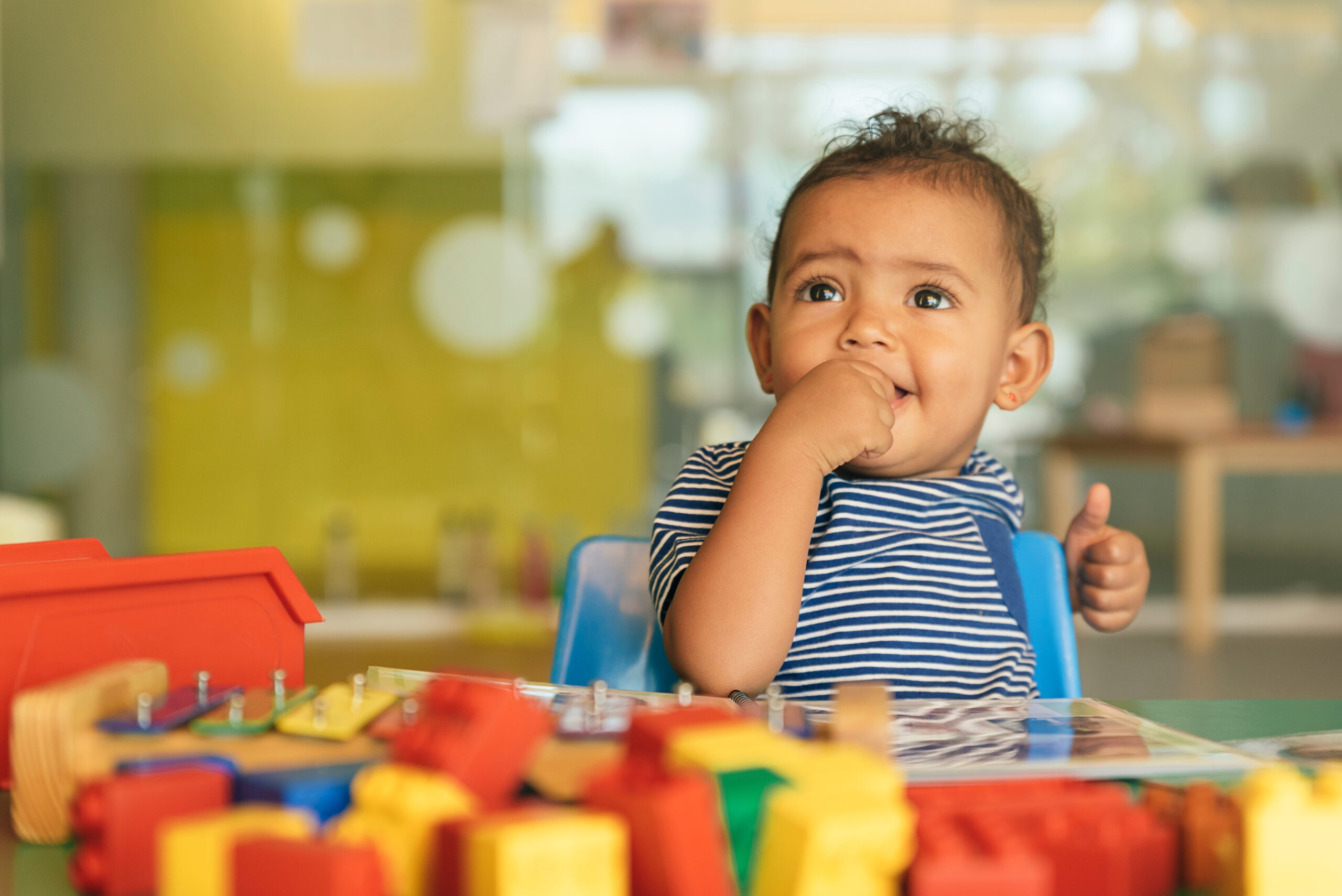 Happy baby playing with toy blocks.
